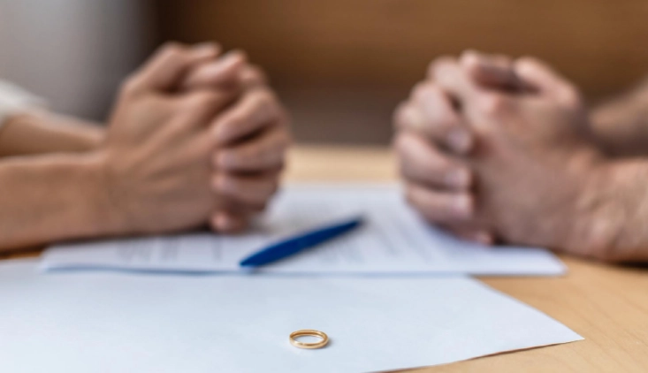 Couple reviewing divorce paperwork with wedding ring on the table during a consultation with a Columbus, Ohio divorce attorney